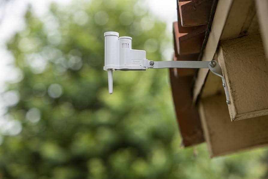 Hunter WR-CLIK wireless rain sensor mounted on house eave with aluminum wall bracket