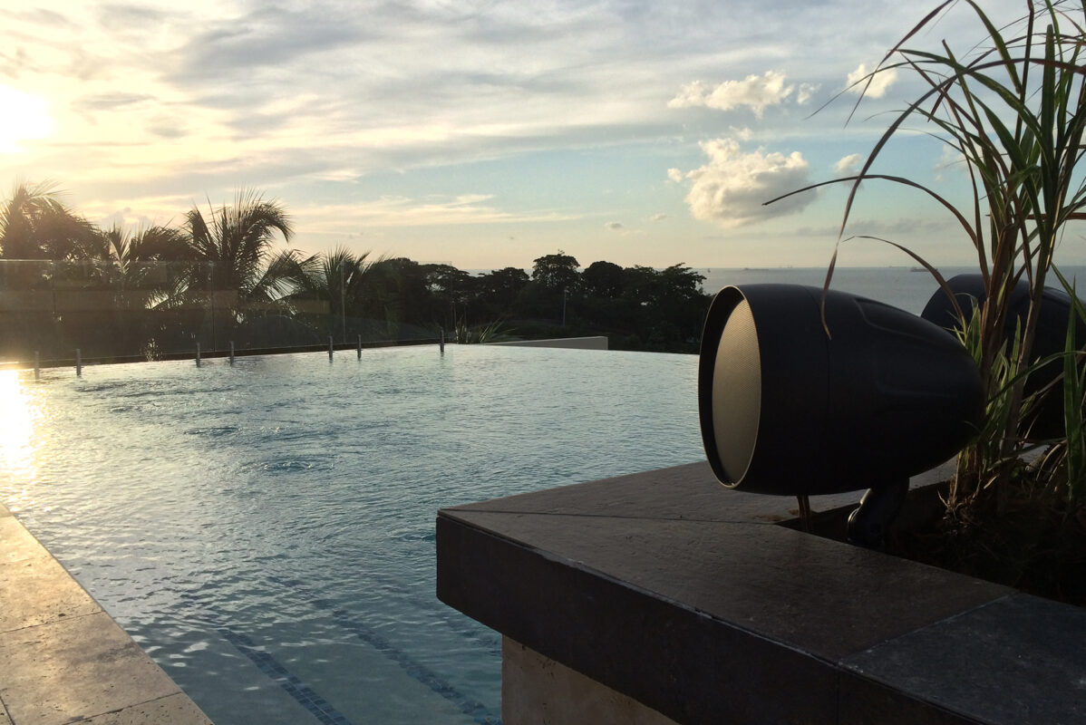 TruAudio Outdoor Audio Systems — Landscape Speakers, Kits & Burial Subs 15 TruAudio landscape satellite aimed across an infinity pool at golden hour